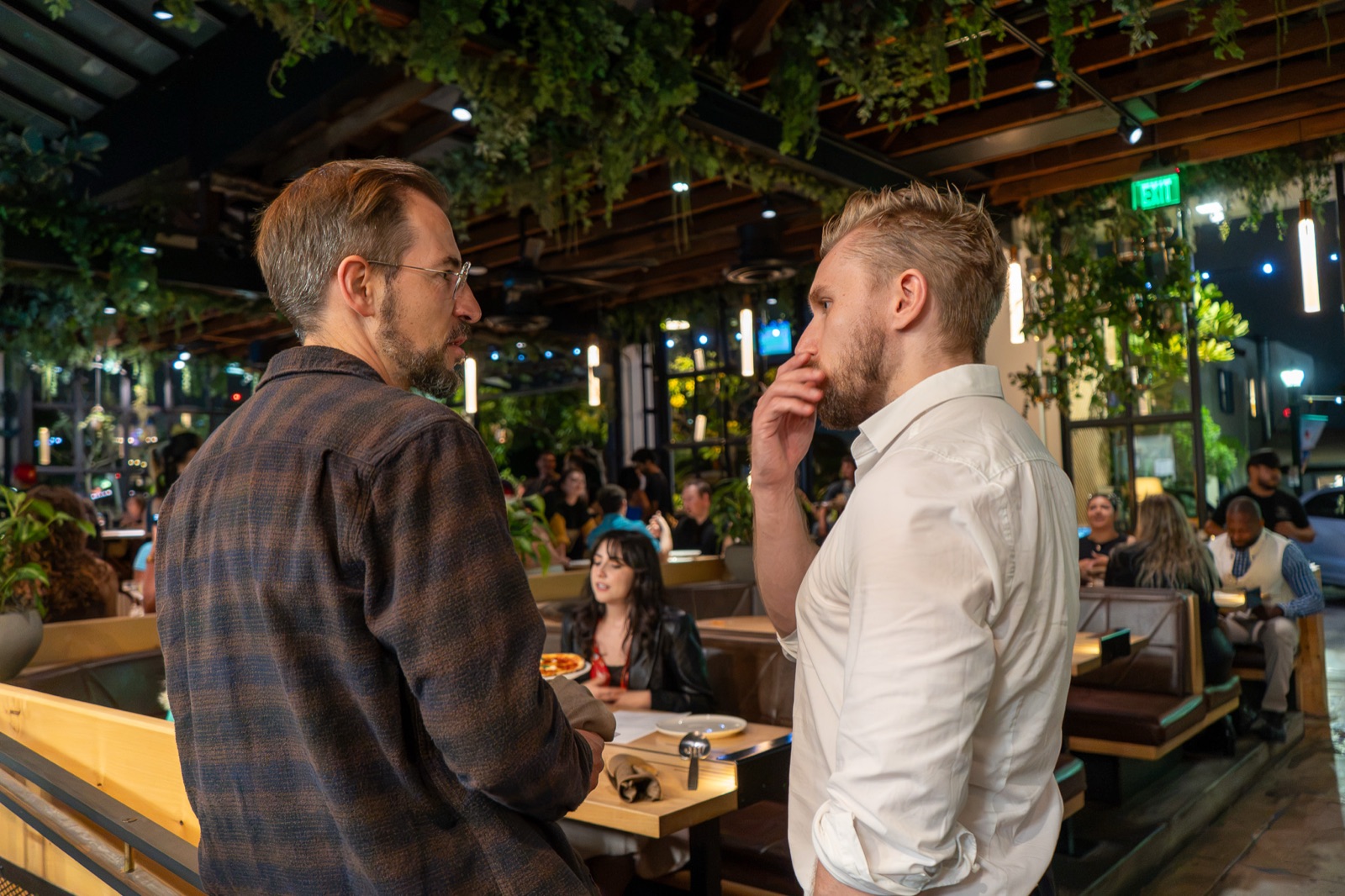 Two guests talking standing beside the table