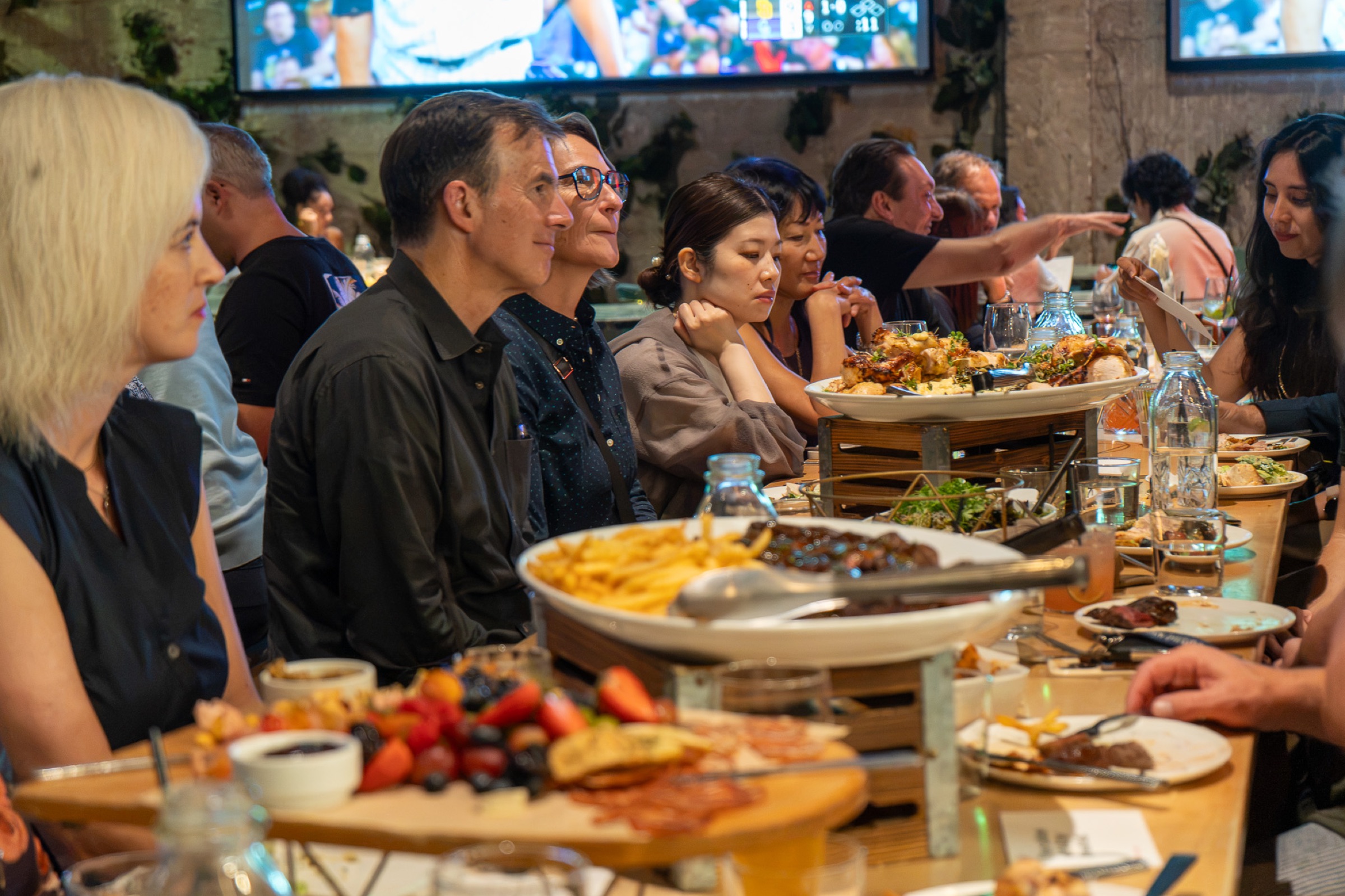 Fourteen design and product leaders at one long table at Nolita Hall, San Diego, during the DDX VIP Dinner